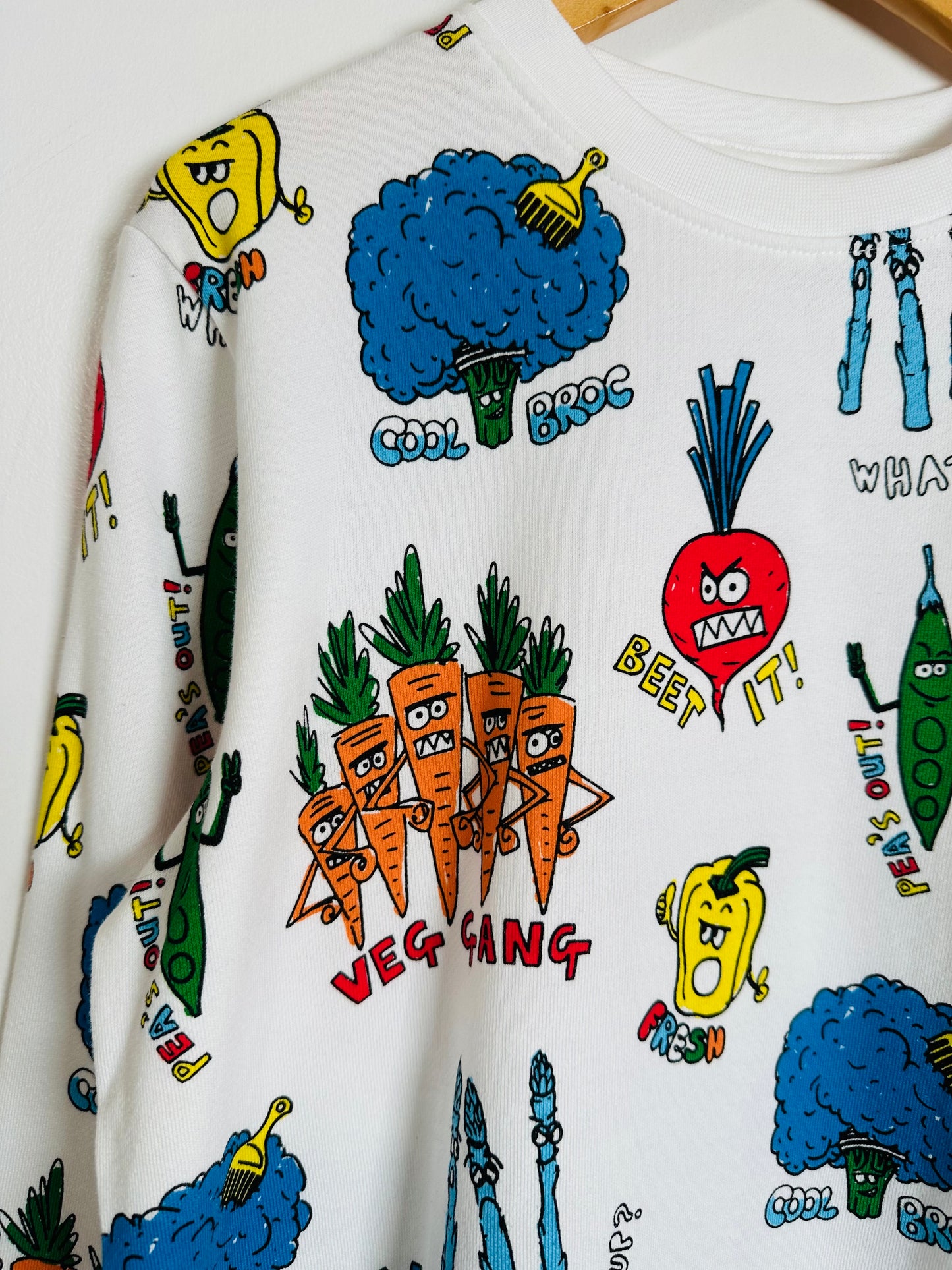 White sweatshirt with colorful vegetable-themed graphics on a white background