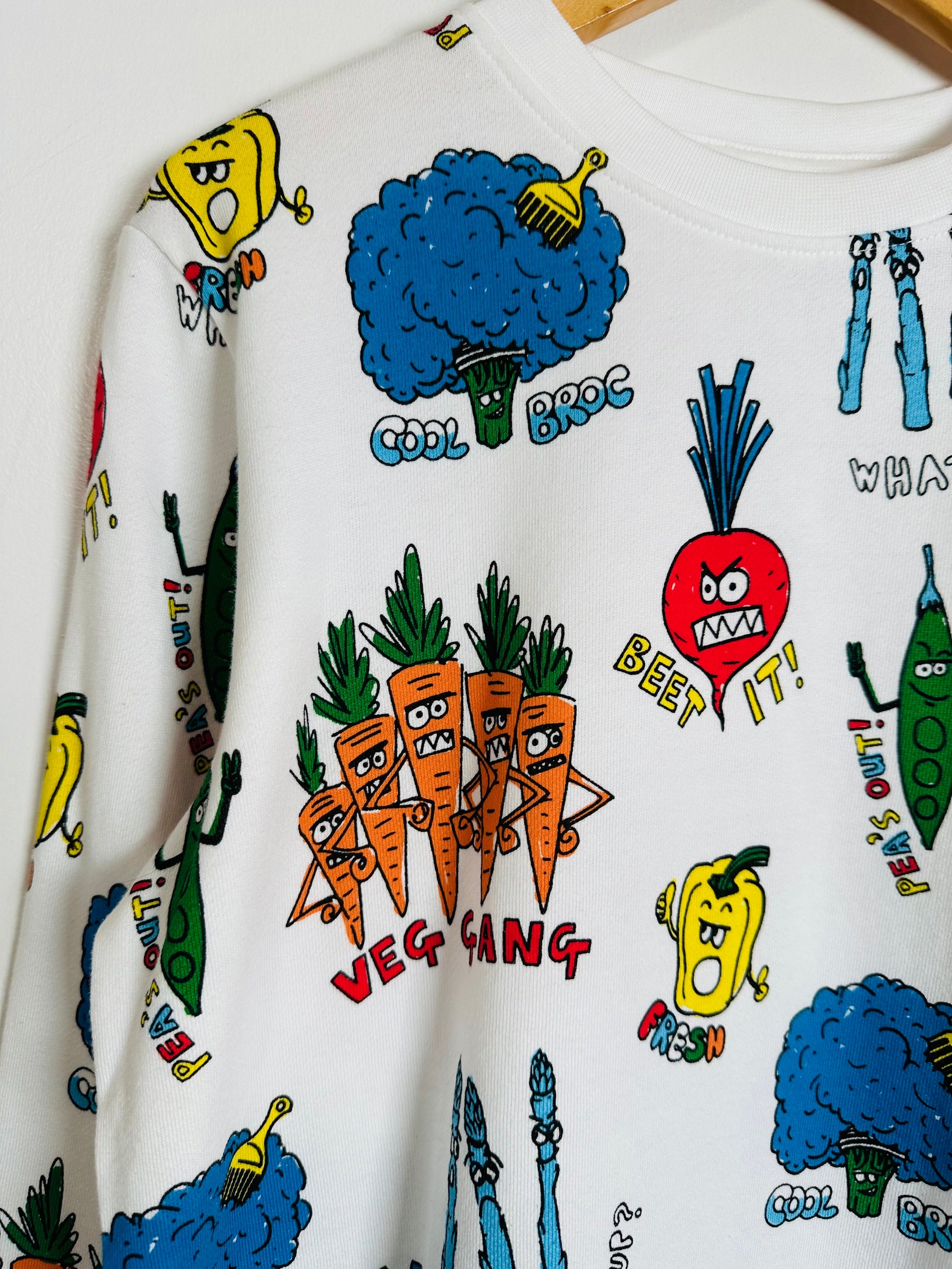 White sweatshirt with colorful vegetable-themed graphics on a white background