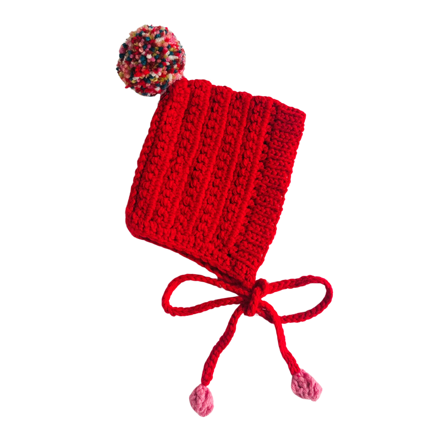 Red knitted baby hat with colorful pom-pom on a white background