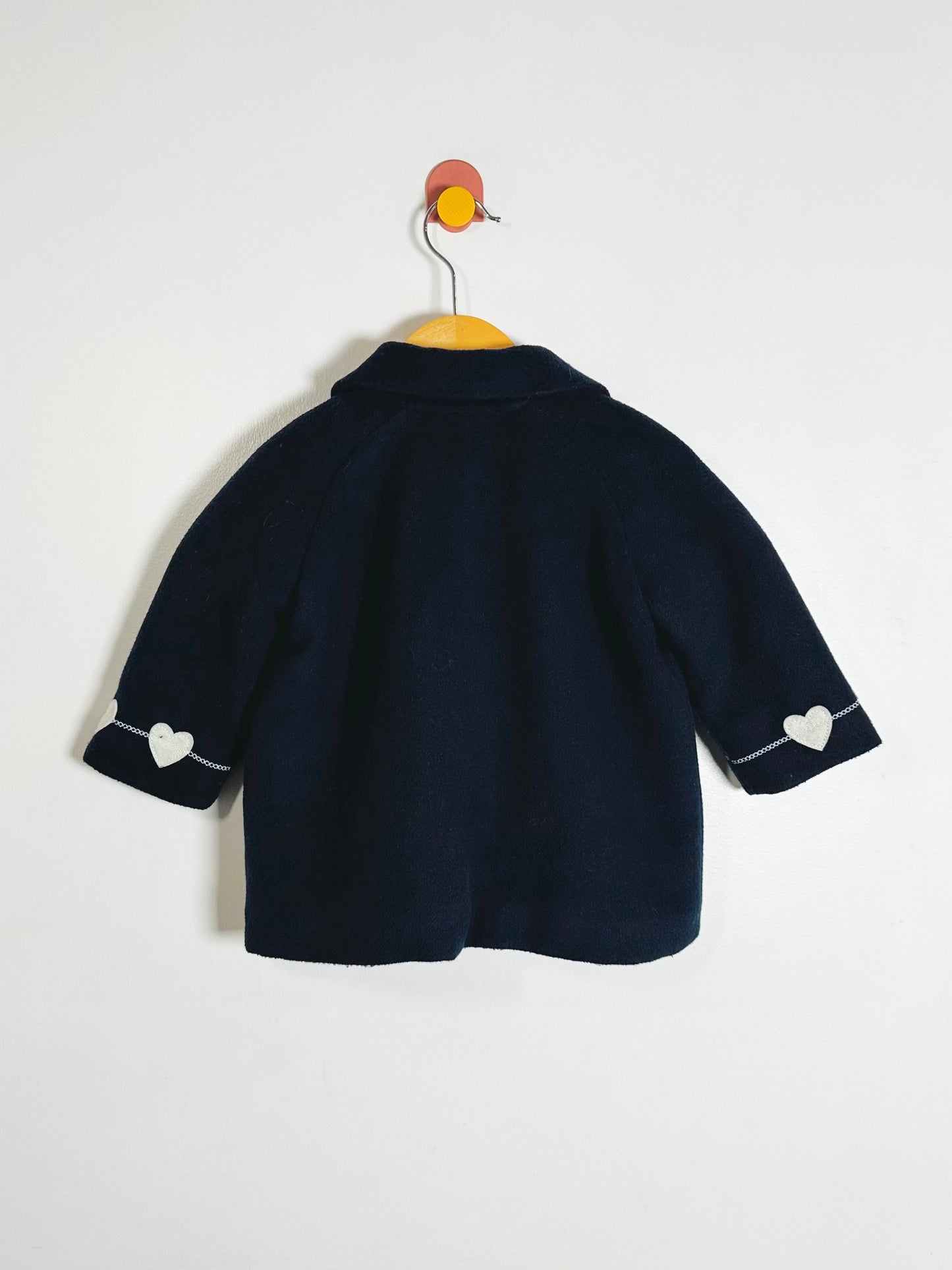 Navy blue children's jacket with heart details on a white background