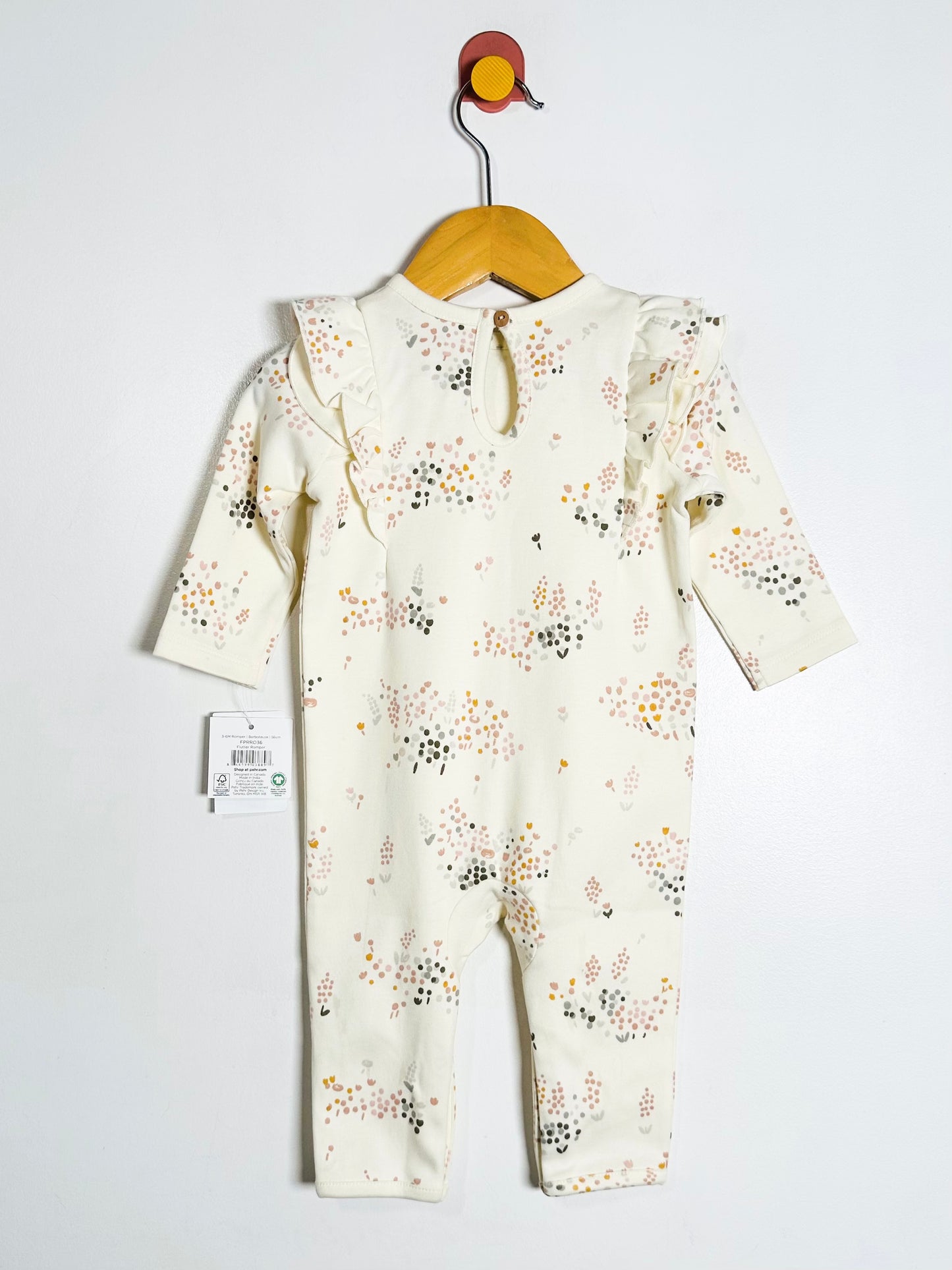 Baby romper with floral pattern on a hanger against a white background