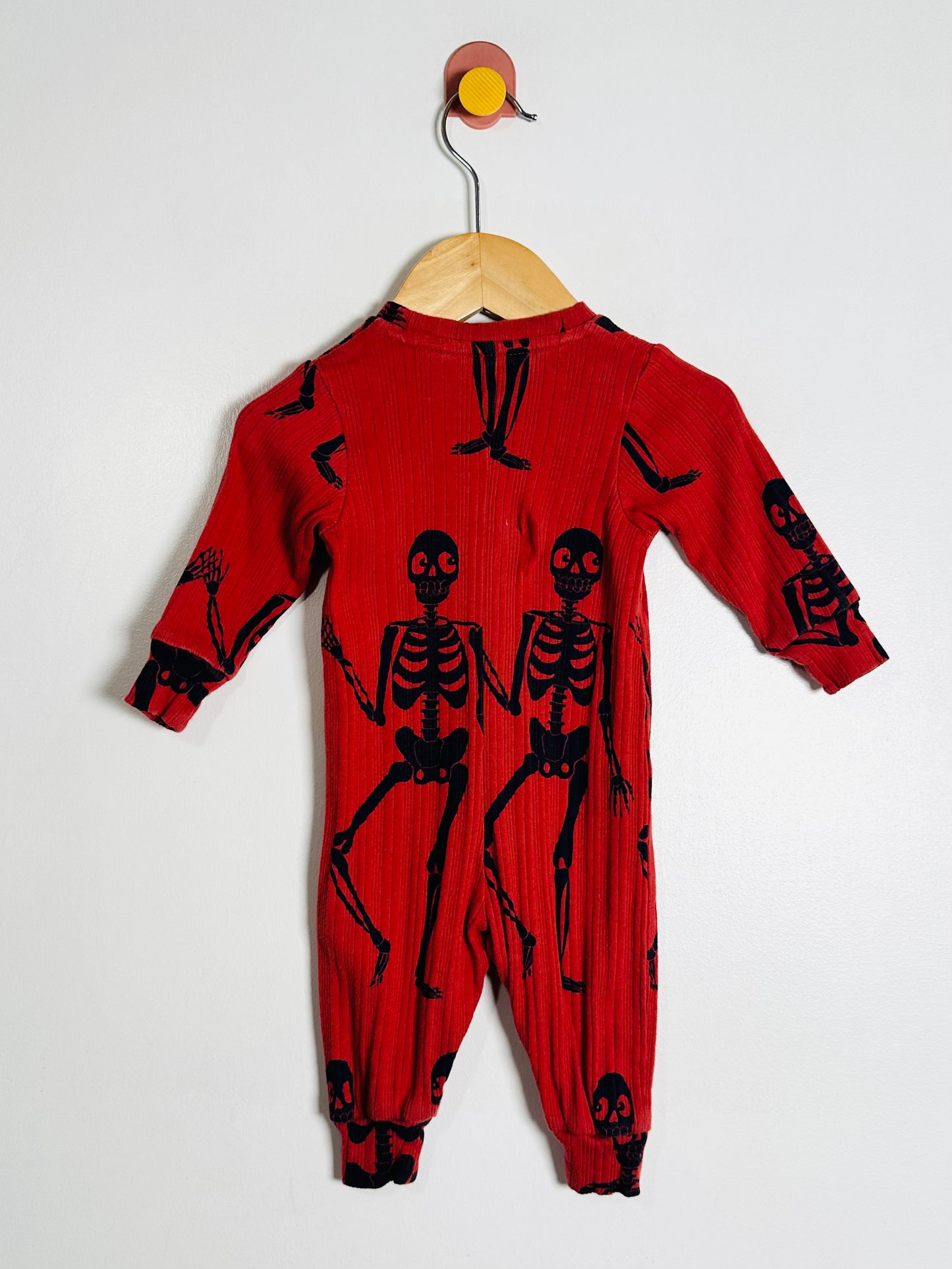 Red onesie with black skeleton designs on a white background