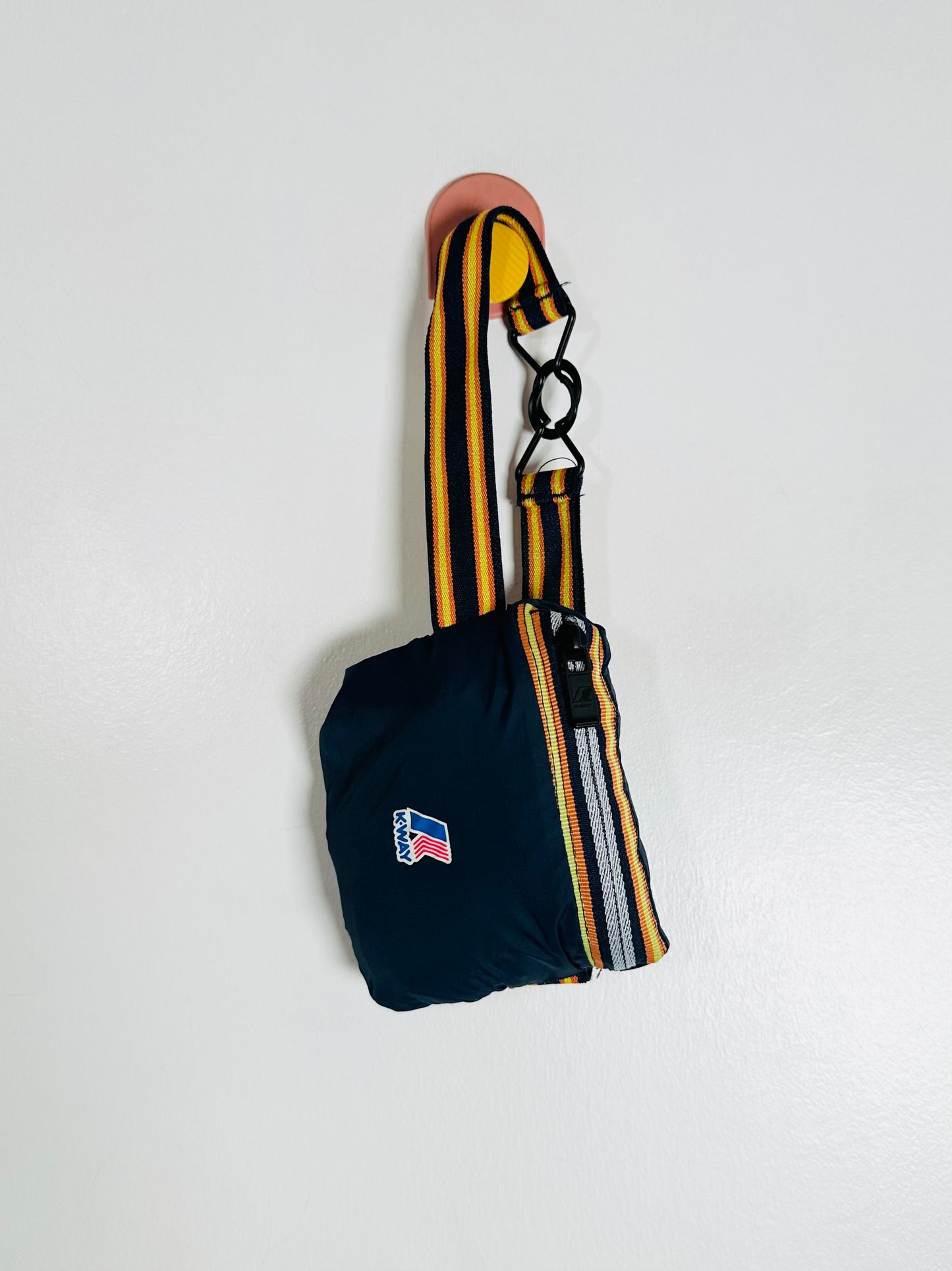 Blue bag with yellow and white striped strap on a light gray background