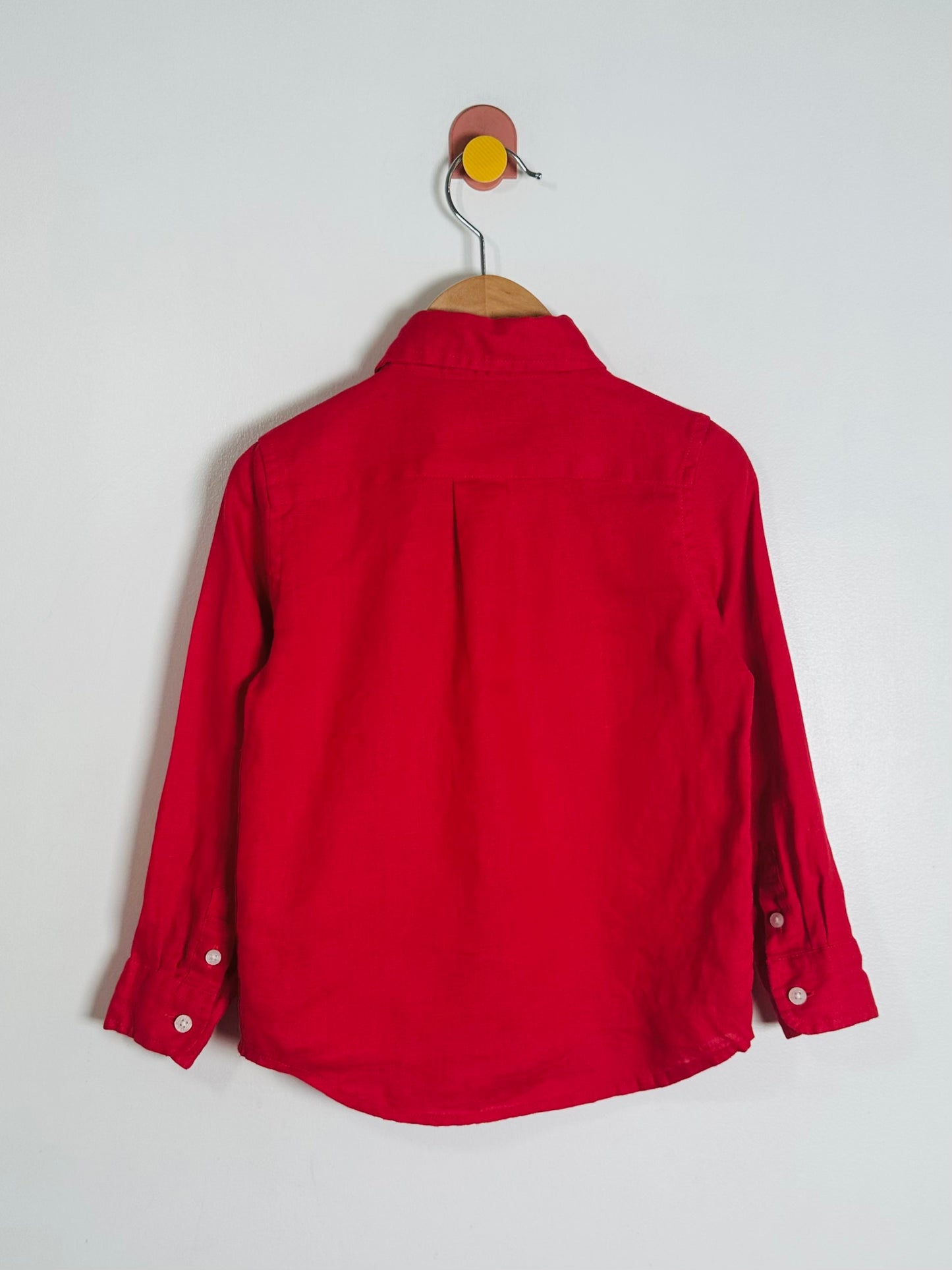 Red shirt on a hanger against a white background