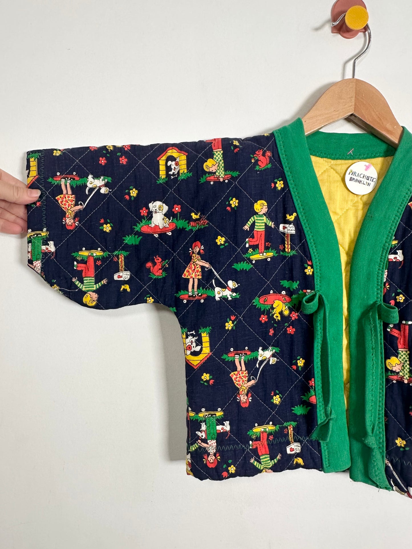 Children's quilted jacket with cartoon dog pattern on a white background