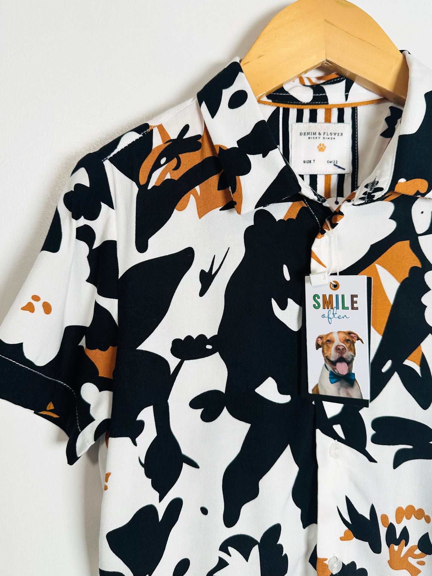 Patterned shirt with a tag featuring a dog on a white background