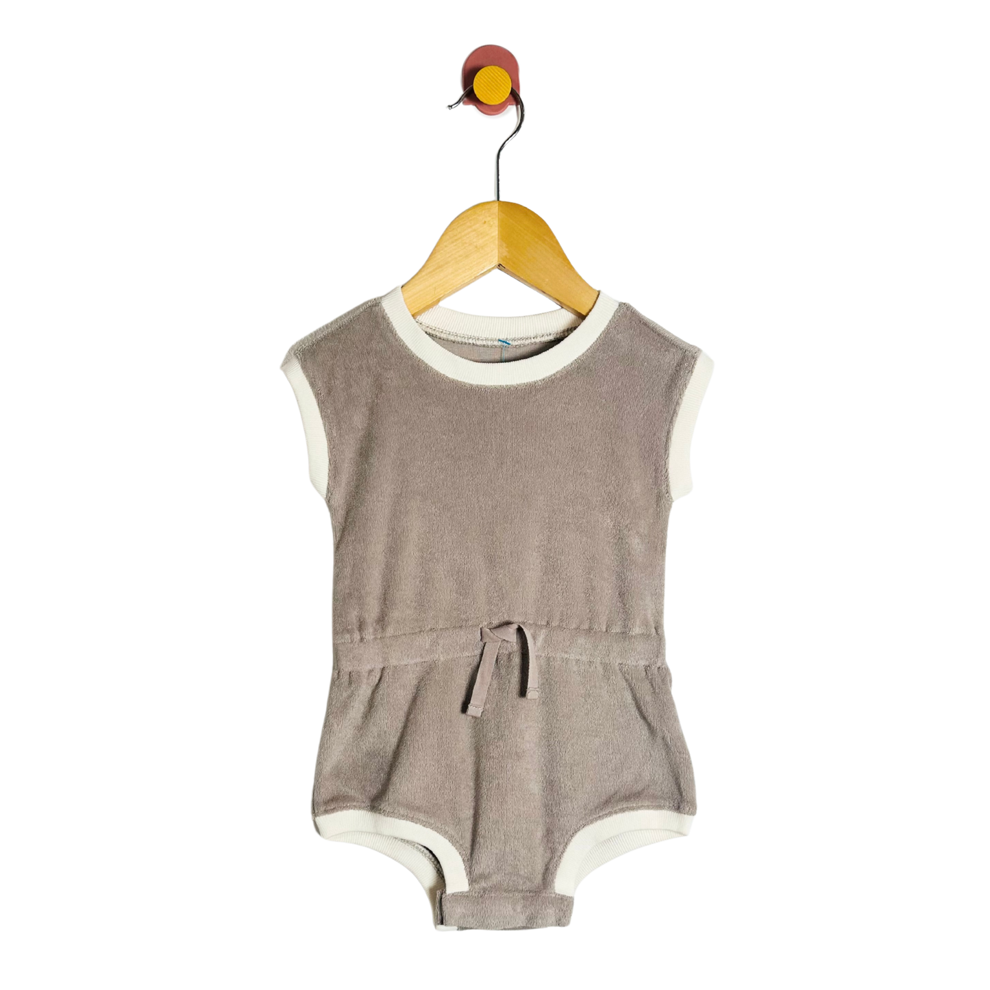 Brown baby romper on a hanger against a white background