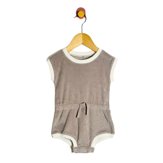 Brown baby romper on a hanger against a white background