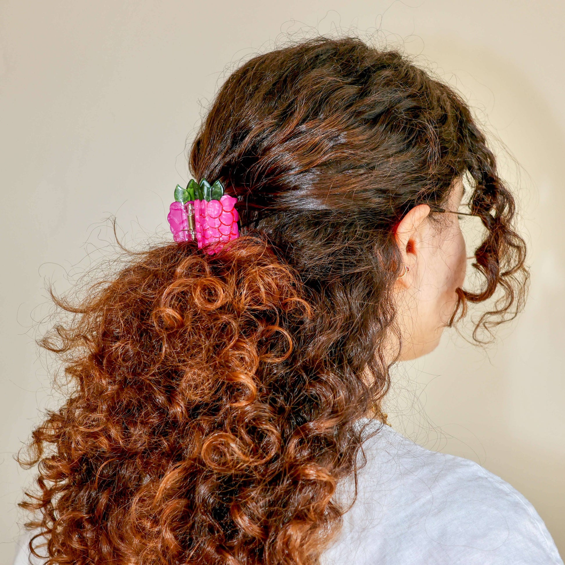 Person with curly hair wearing a Jenny Lemons - Mini Raspberry Hair Claw Clip