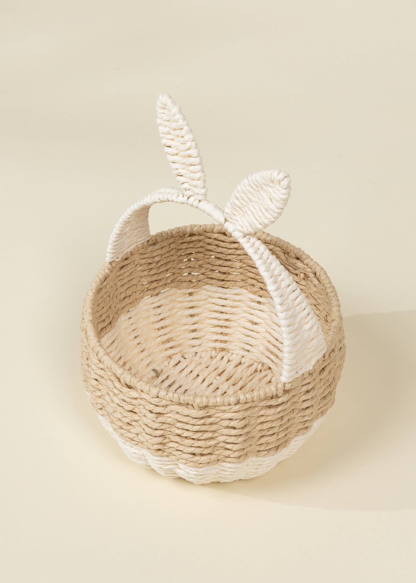 Woven basket with bunny ears on a beige background