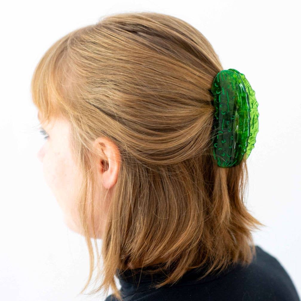 Green hair clip on a person's hair against a white background