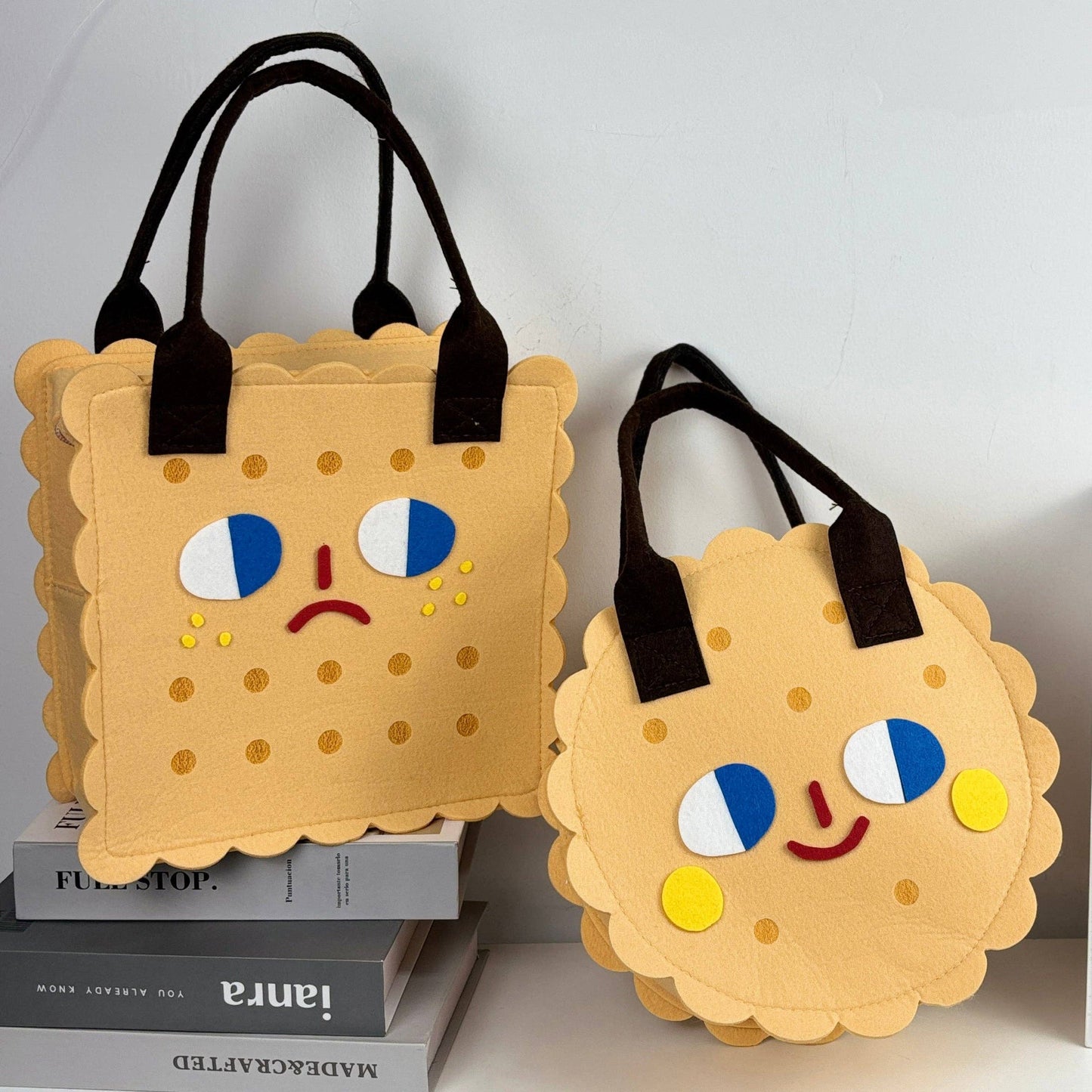 Two cookie-shaped bags with facial expressions on a white background