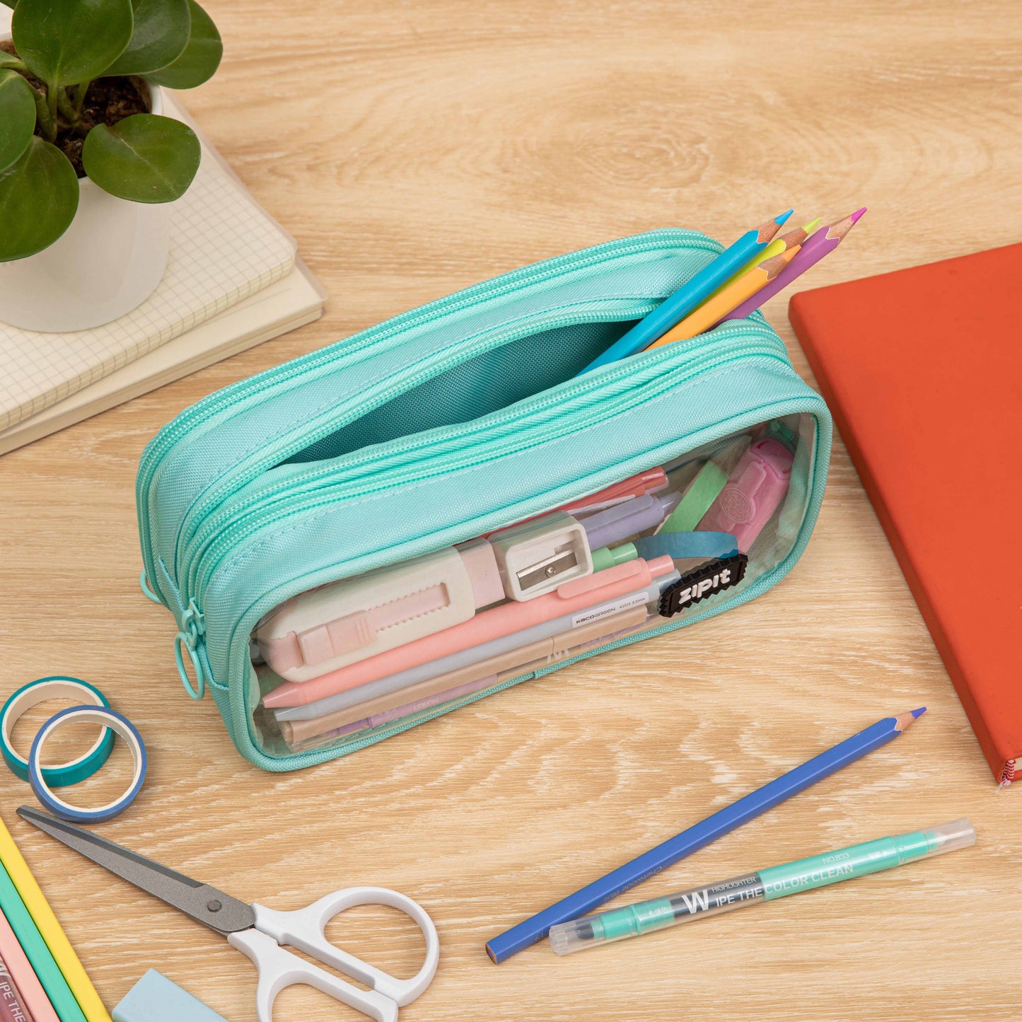 Turquoise pencil case with stationery items on a wooden surface