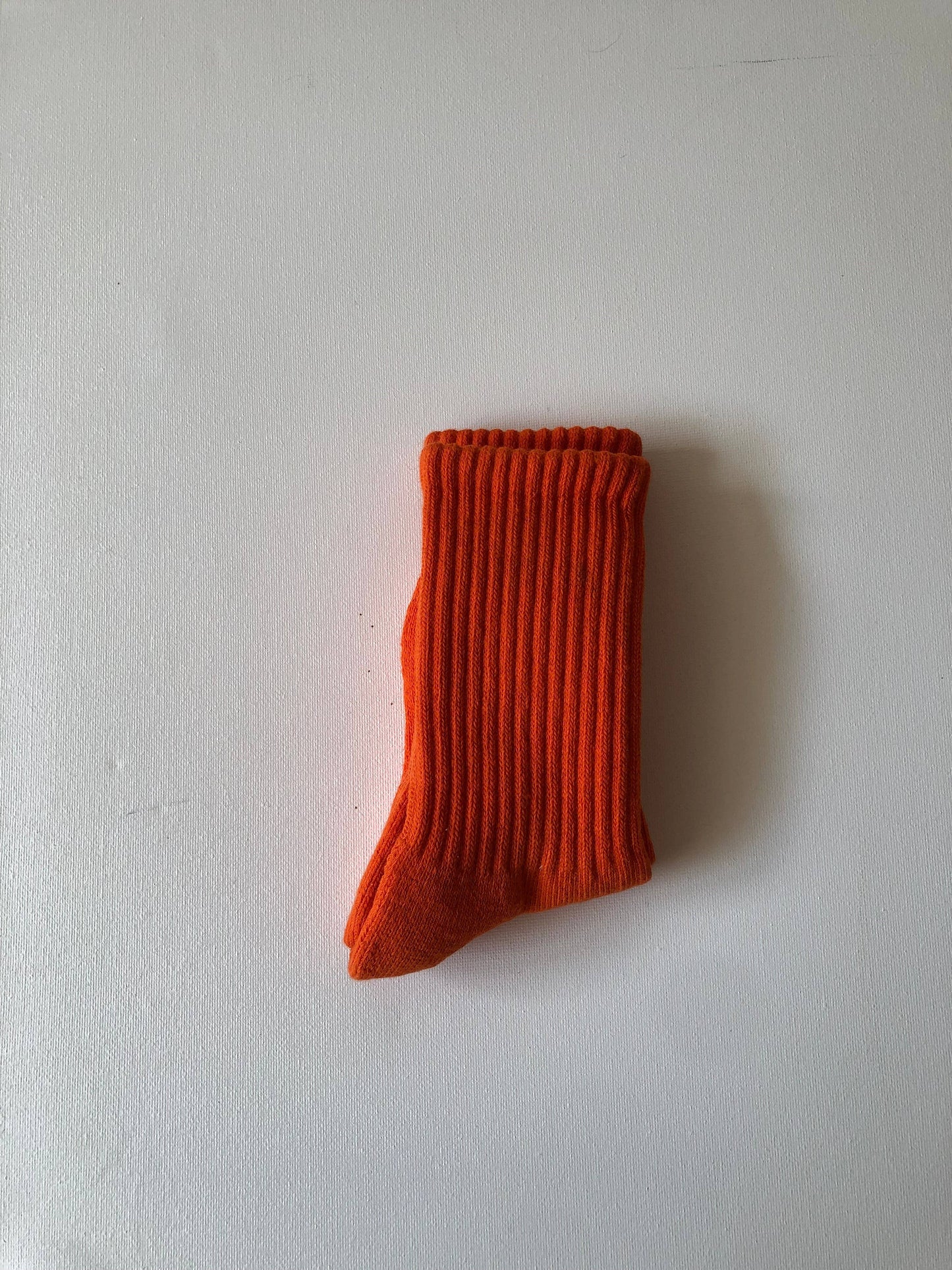 Single orange sock on a white background