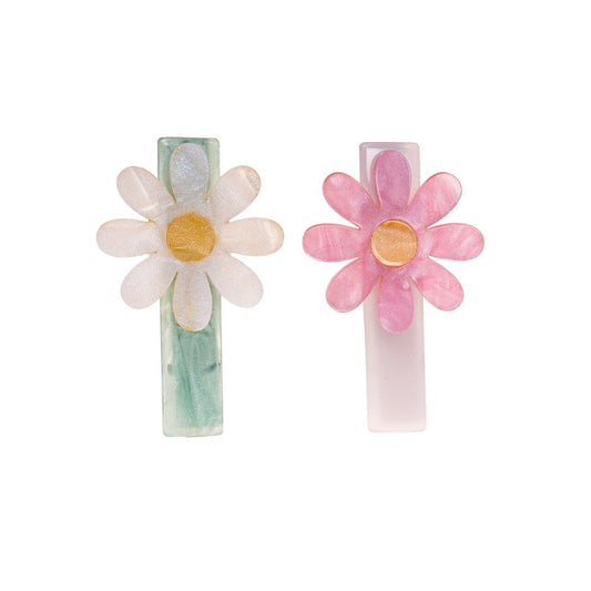Two floral hair clips, one white and yellow, one pink and yellow, on a white background.