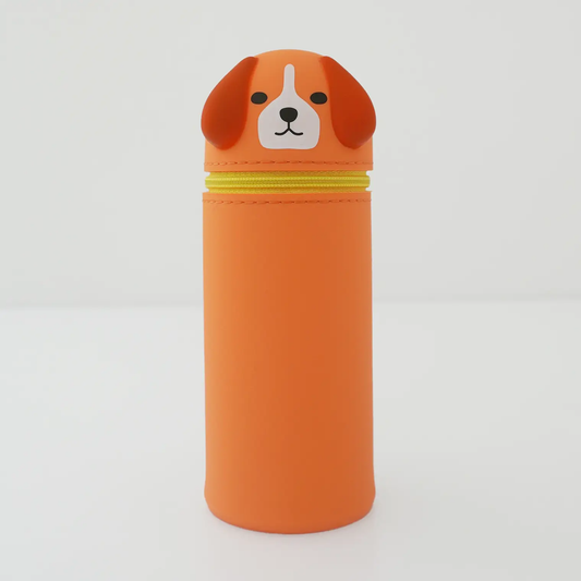 An orange pencil case with dog-shaped lid, featuring floppy brown ears, a white snout, and black eyes, set against a plain light gray background.