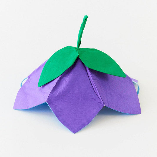 Purple flower-shaped hat with green leaves on a white background