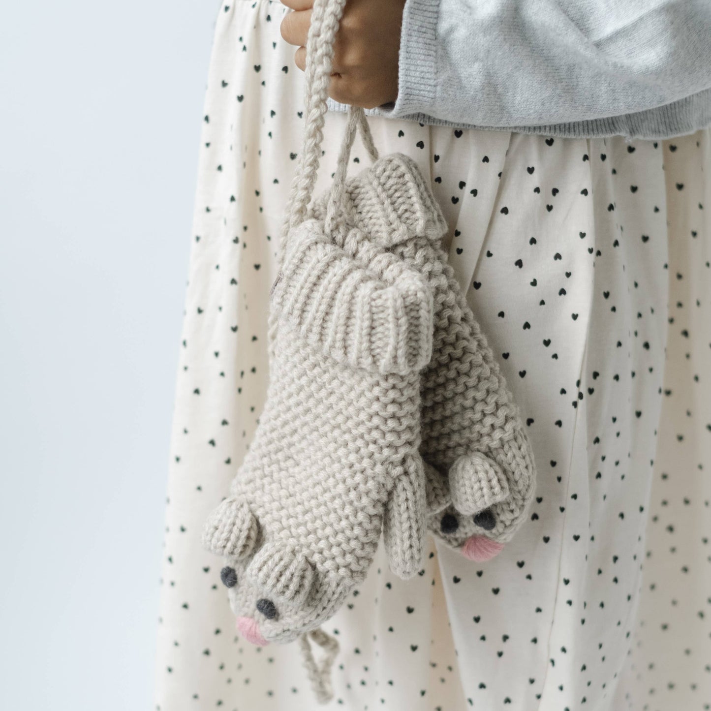 Handmade crochet bunny bag held by a person wearing a polka dot dress.