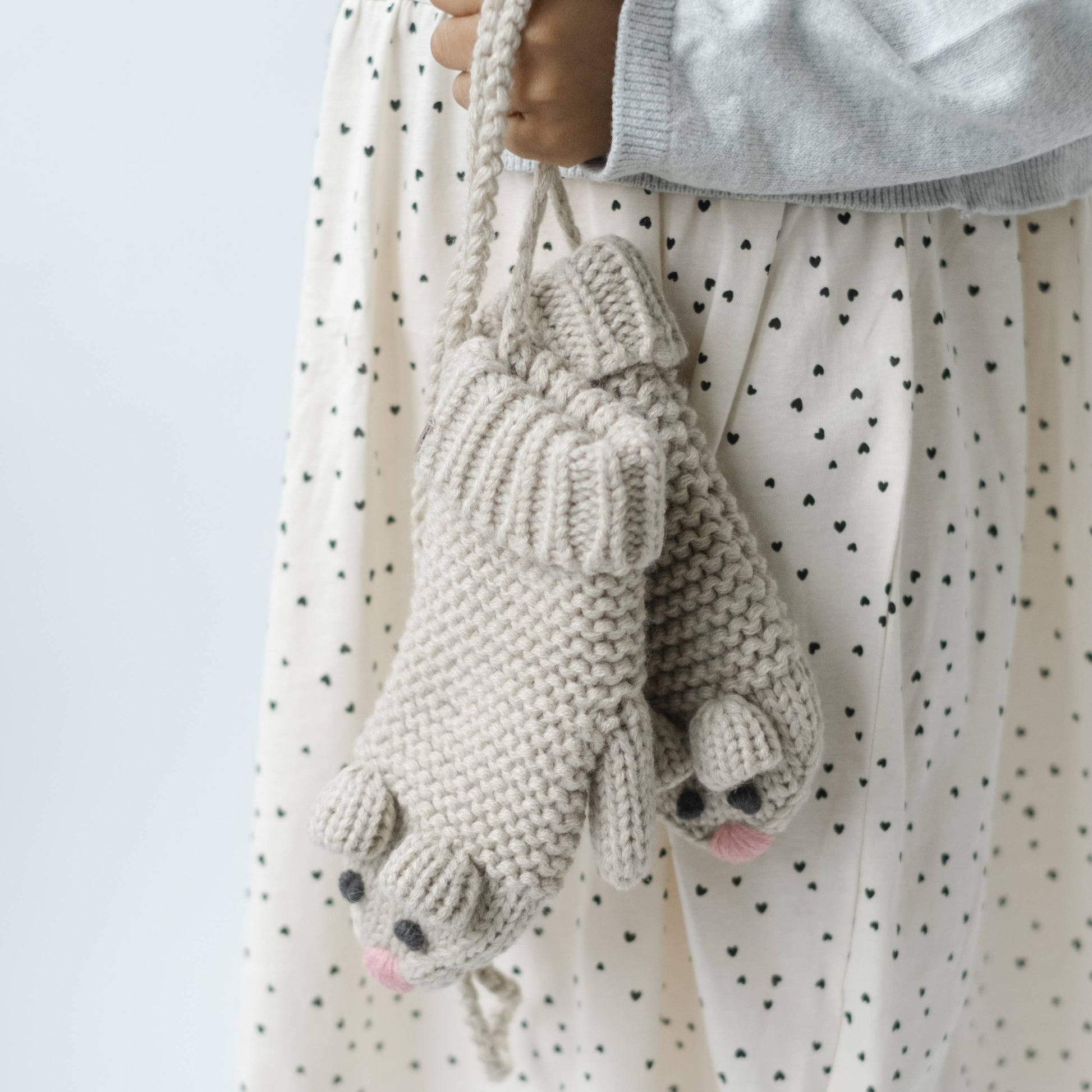 Handmade crochet bunny bag held by a person wearing a polka dot dress.
