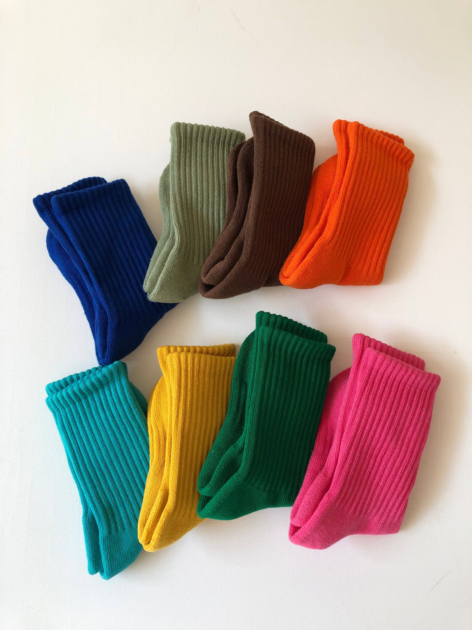 Colorful socks arranged in a scattered pattern on a white background