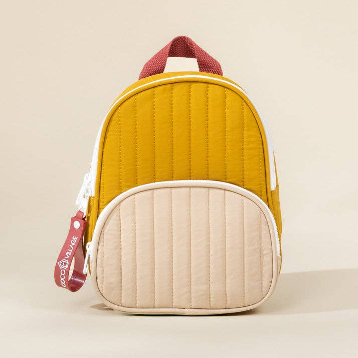 Yellow and beige quilted backpack with red accents on a beige background