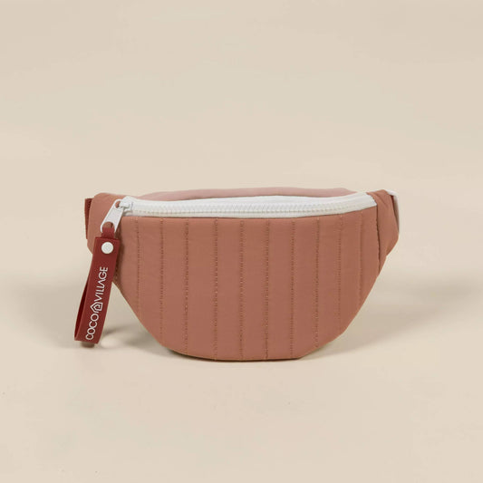 Brown quilted waist bag with a white zipper on a beige background