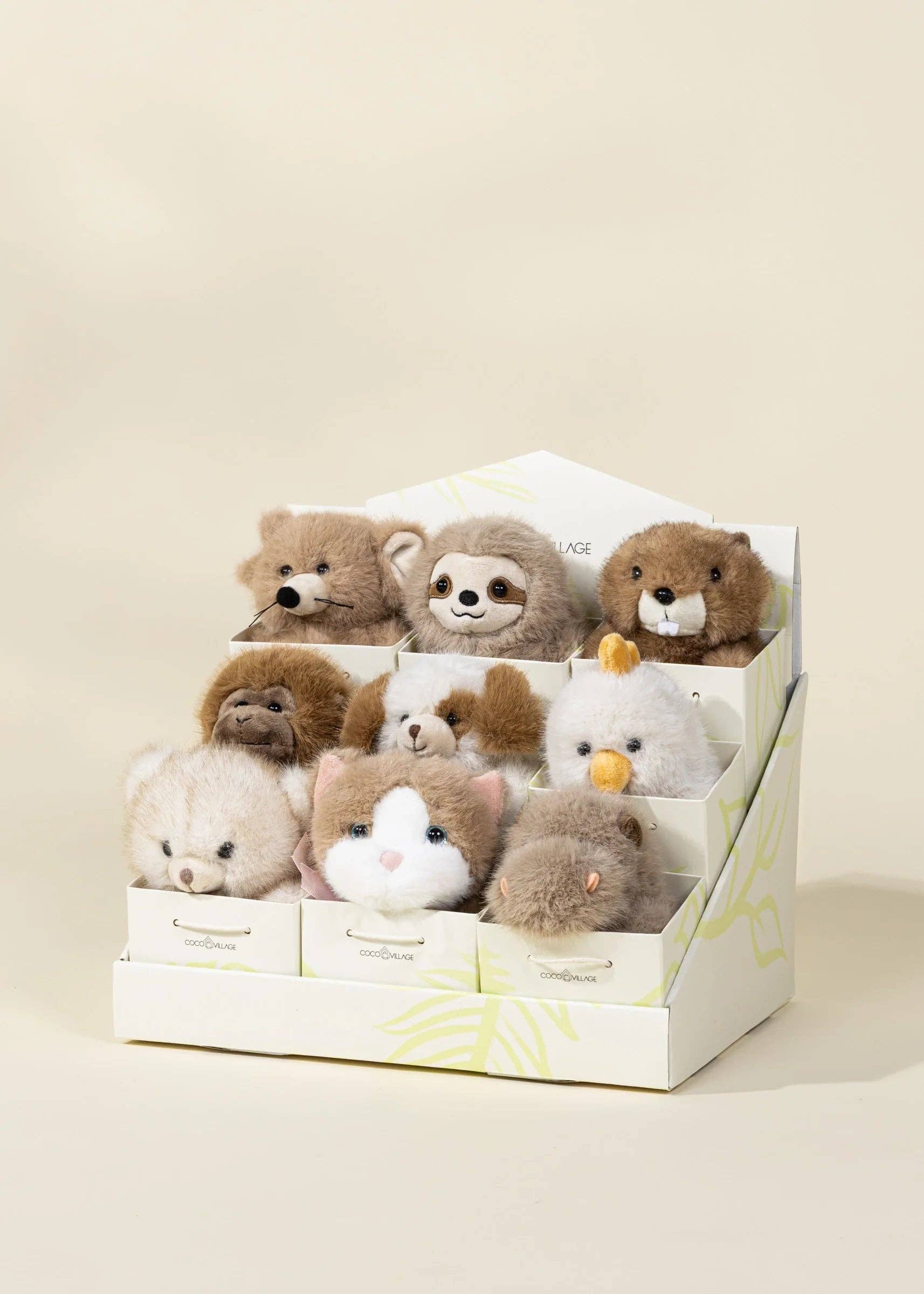 Set of small stuffed animals in a display box on a beige background