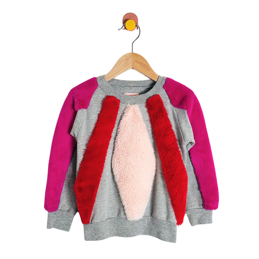 Children's sweater with pink, red, and gray design on a hanger against a white background