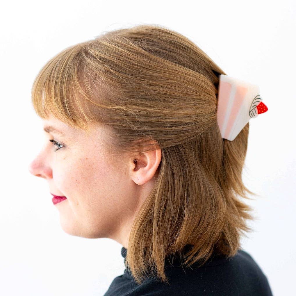 Woman with a ponytail held by a decorative hair claw against a white background