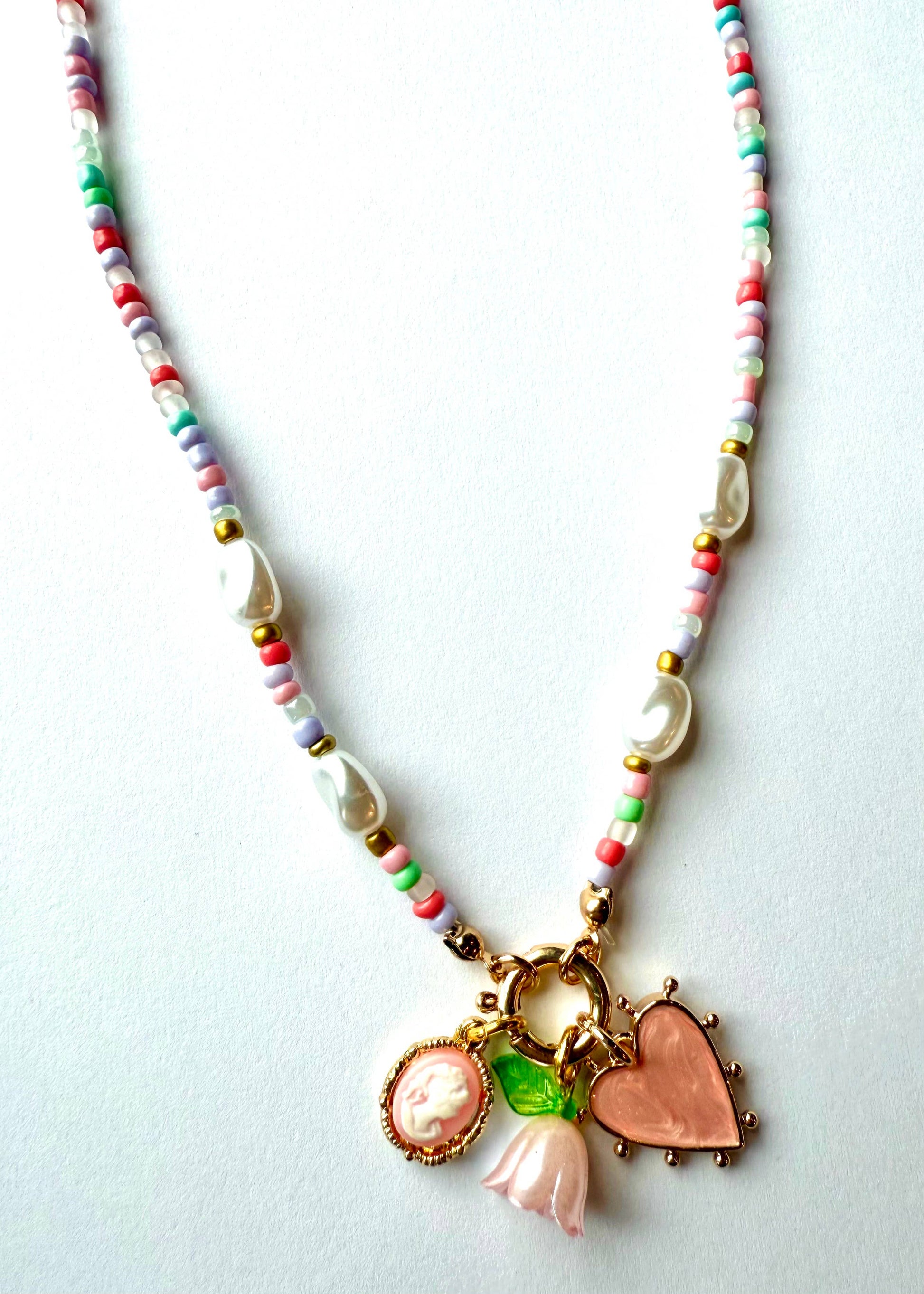 Necklace with colorful beads and various charms on a light background