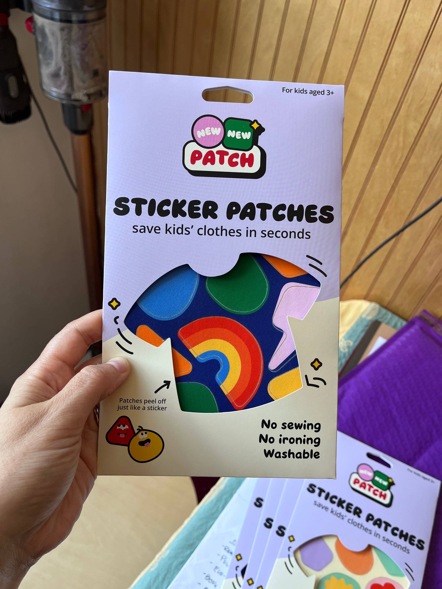 Hand holding a package of 'New Patch' sticker patches with colorful designs.