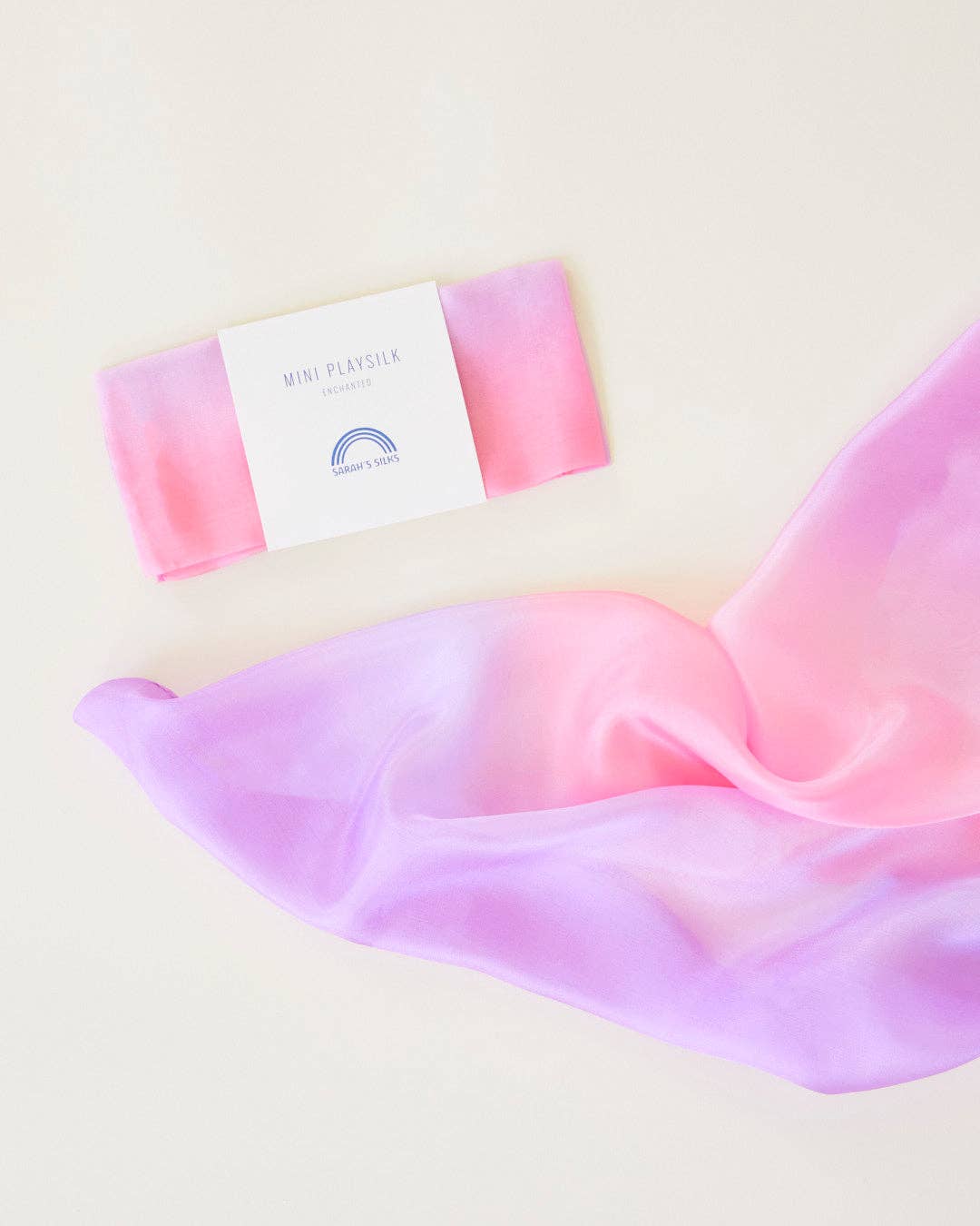 Pink and purple gradient scarf with a brand label on a light background
