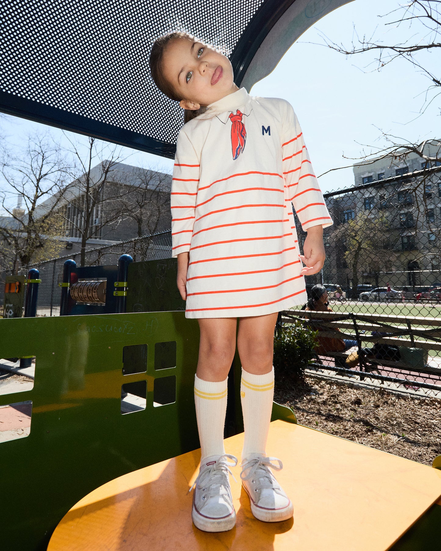 Child wearing a striped dress in an outdoor setting