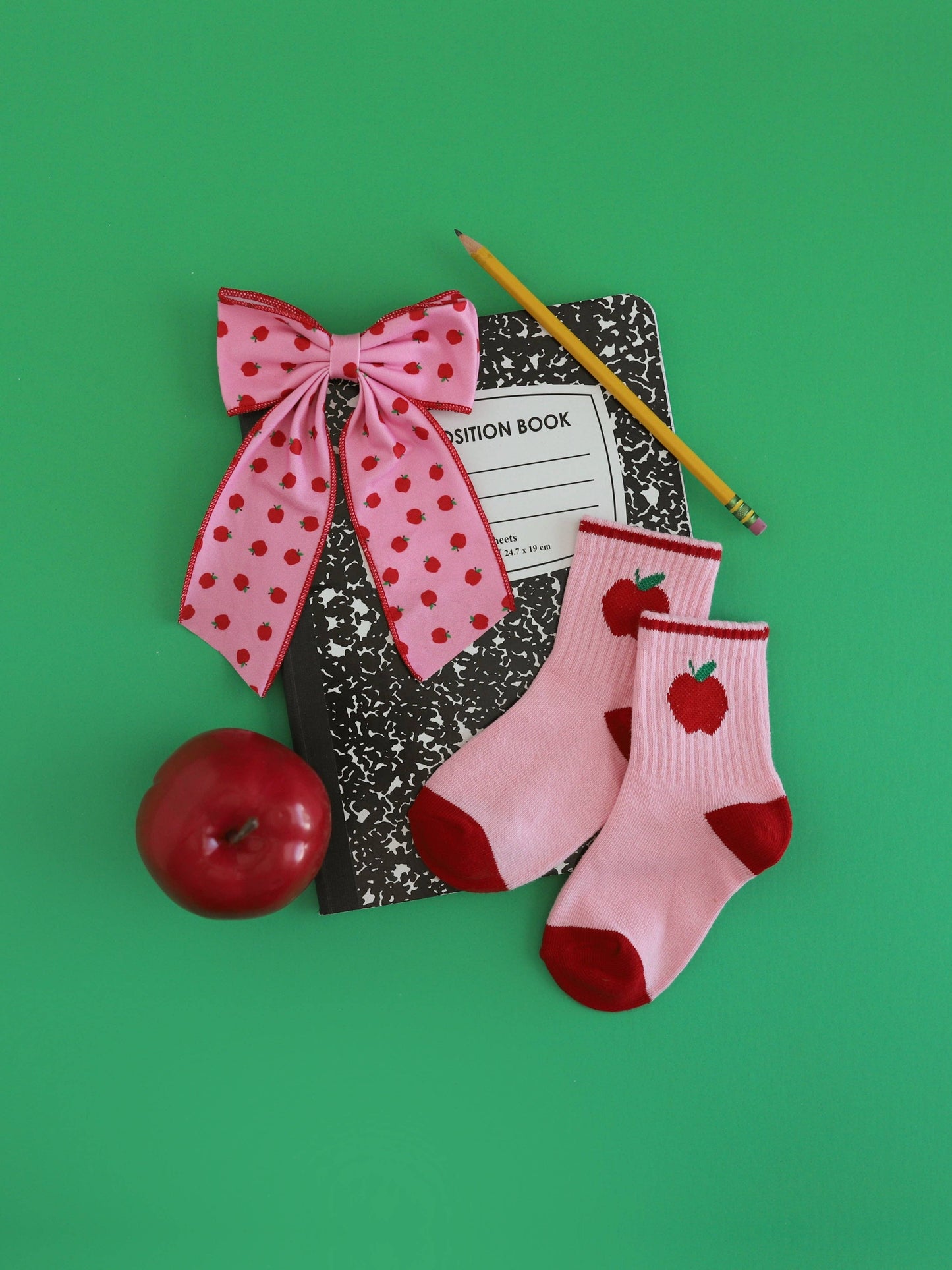 school supplies, a hair bow, sock and an apple
