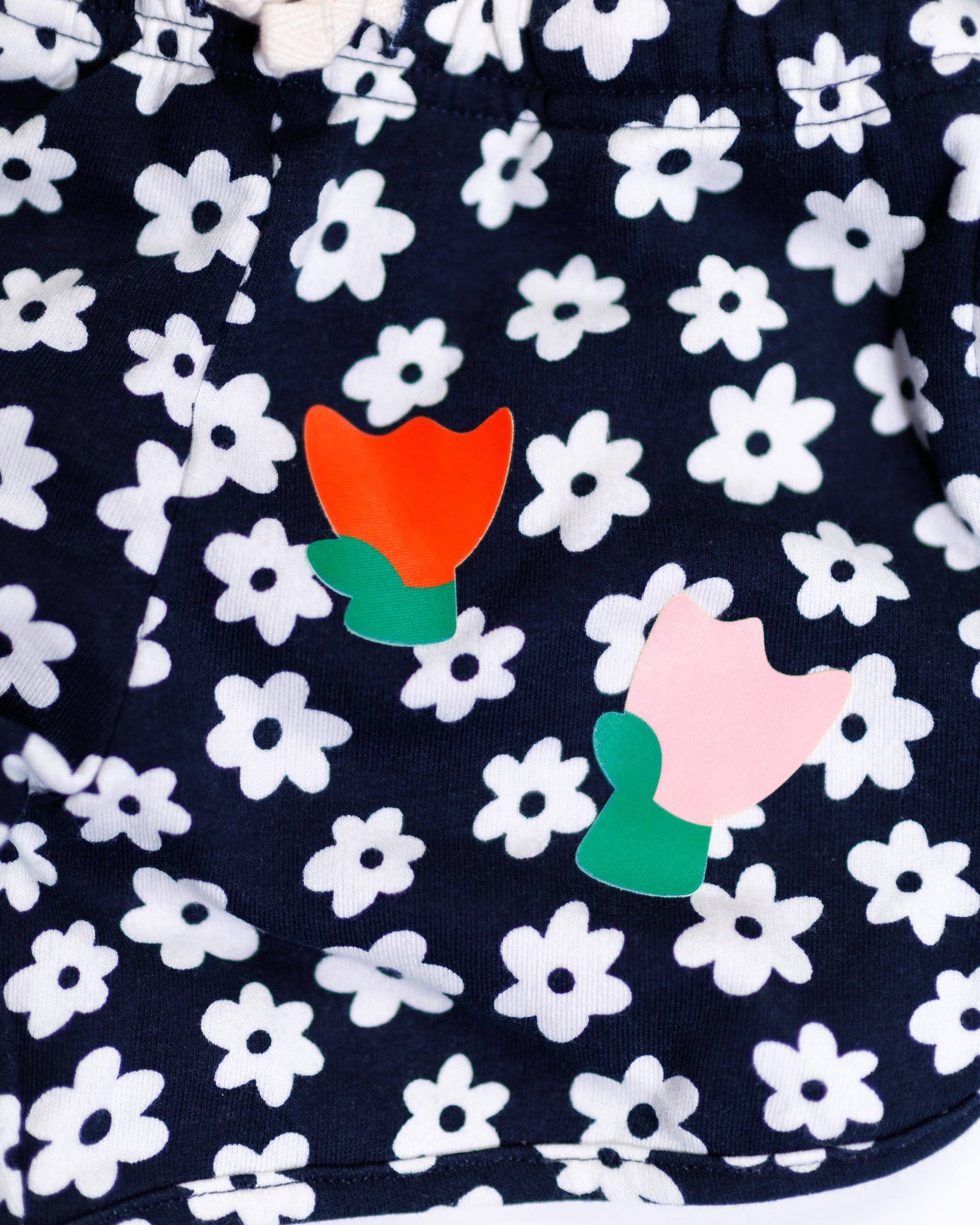 Navy blue fabric with white floral pattern and colorful tulip designs.