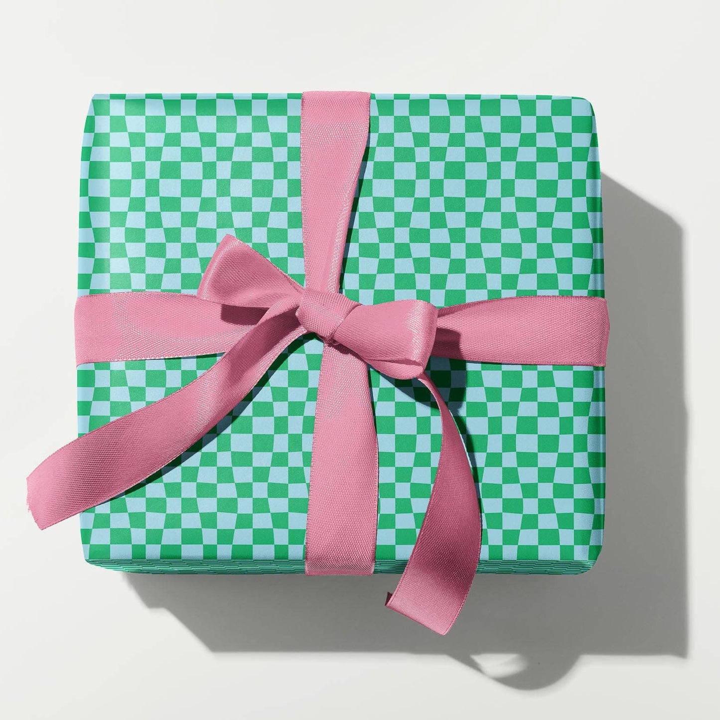 Green checkered gift box with a pink ribbon on a white background