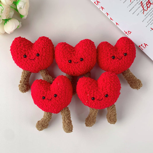 Red heart-shaped plushies with smiling faces on a white background