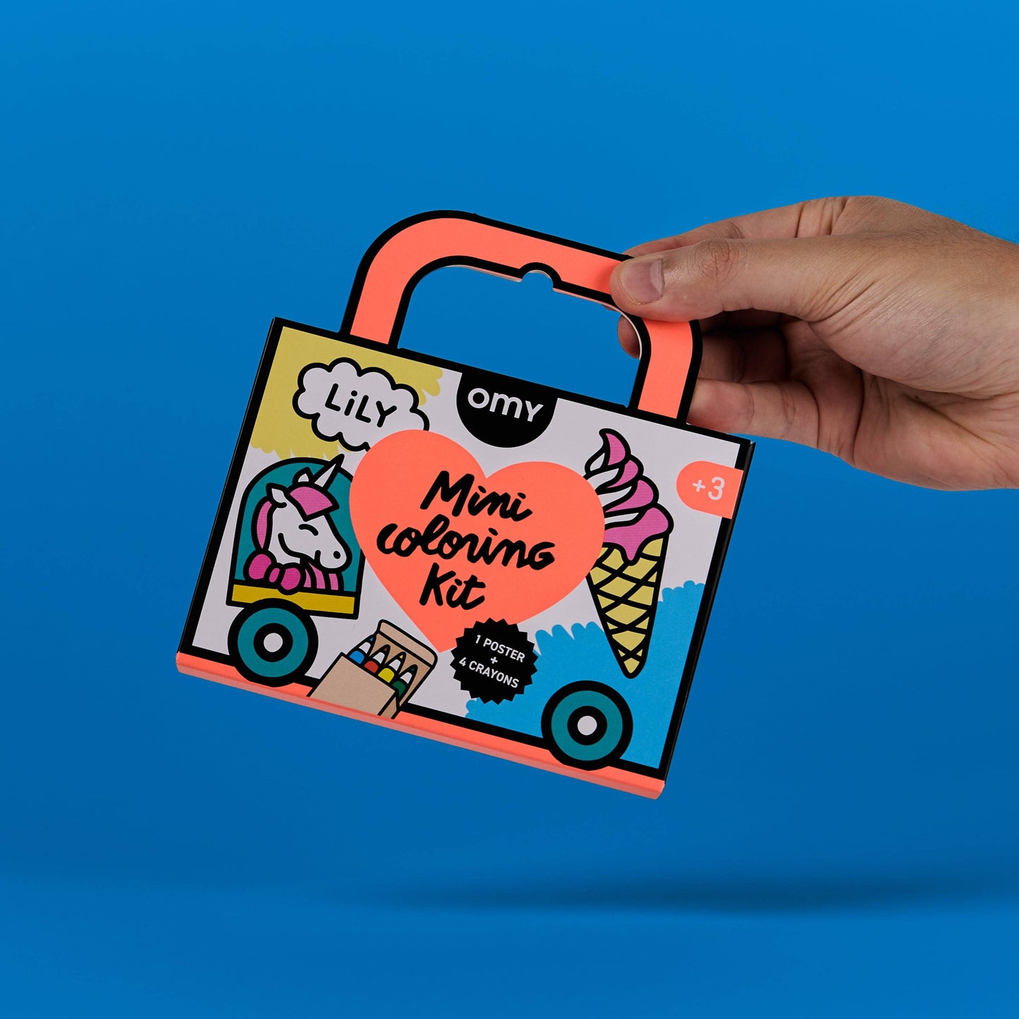 Hand holding a mini coloring kit against a blue background