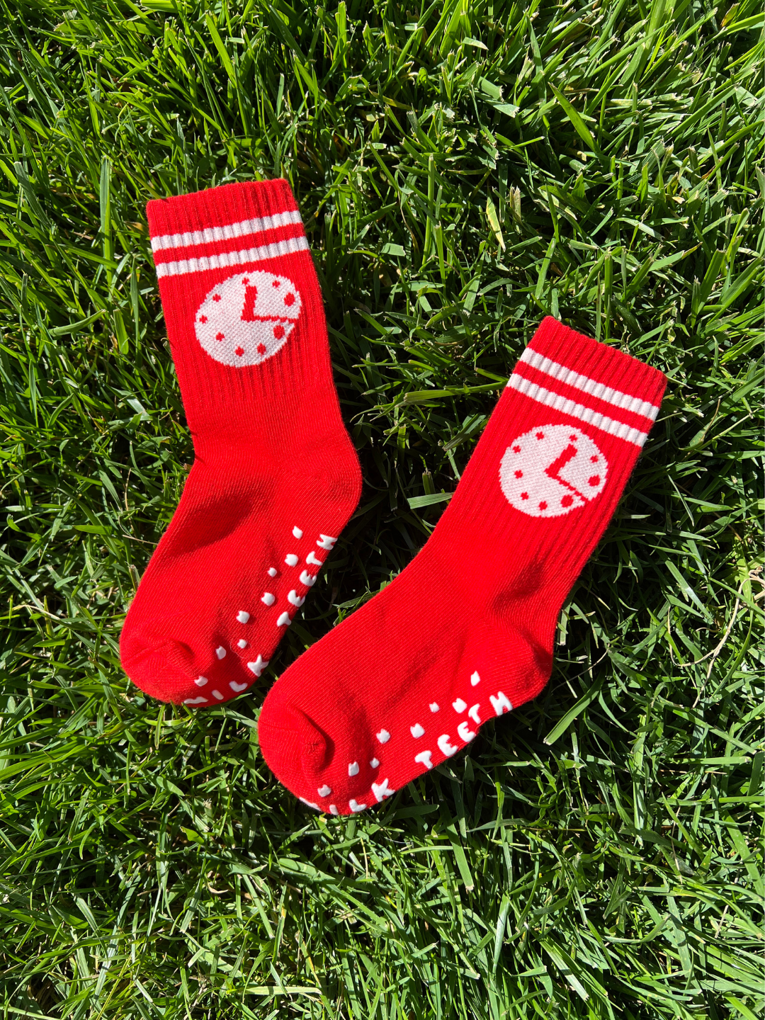 Red socks with white patterns on grass
