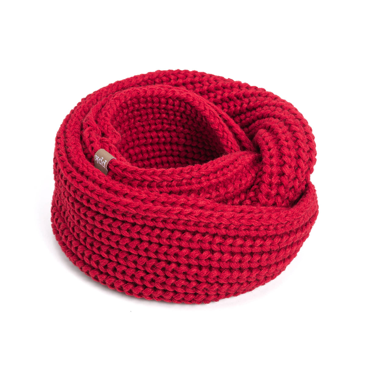 A chunky knit red infinity scarf coiled on a white background