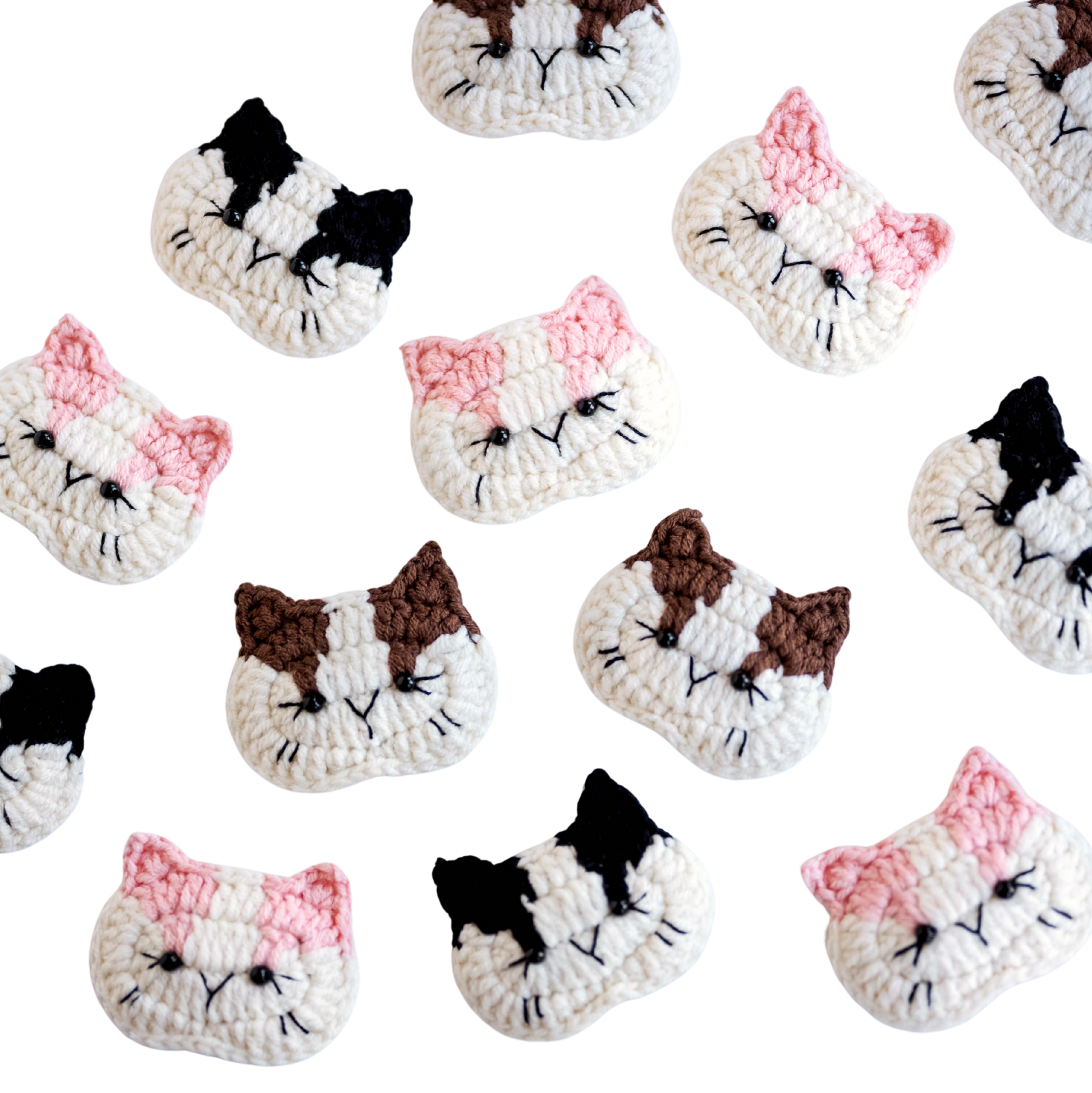 Pattern of crocheted cat face designs on a white background