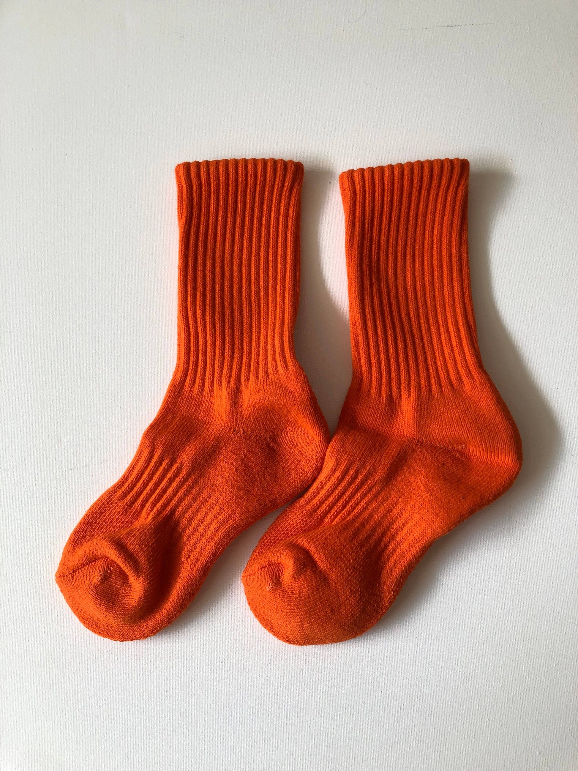Pair of orange socks on a white background