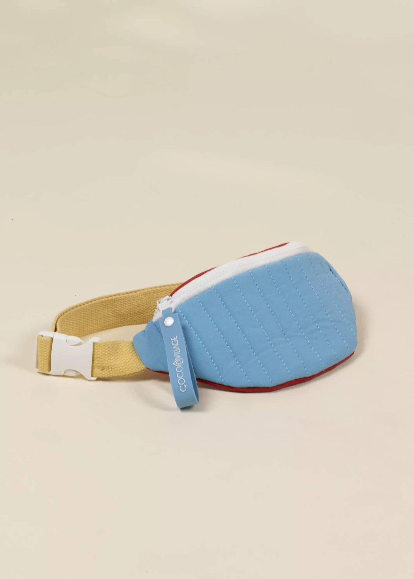 Blue pouch with a beige strap on a beige background