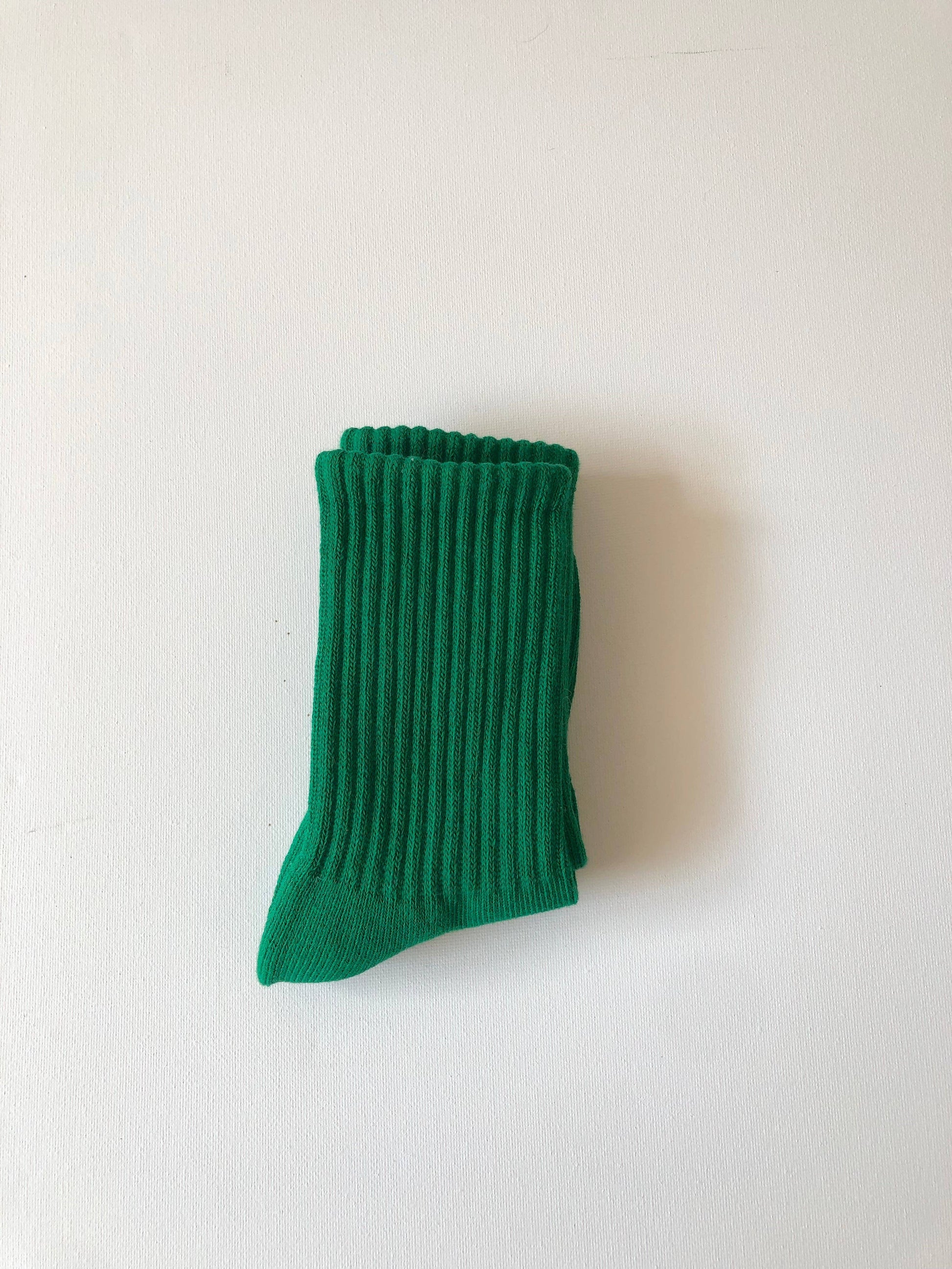 Green ribbed sock on a white background