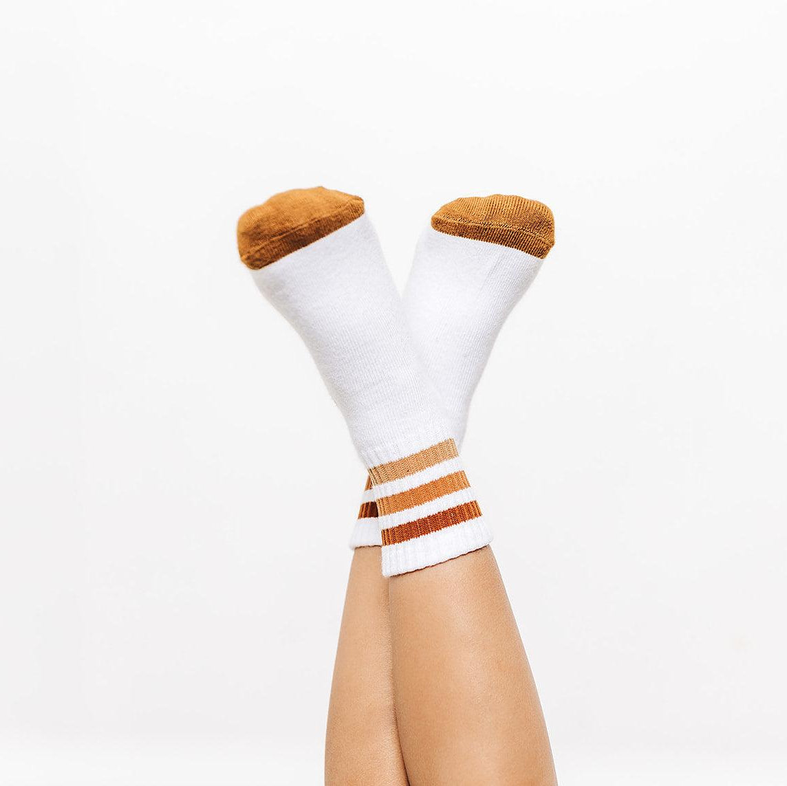 White socks with brown accents worn by a person on a white background