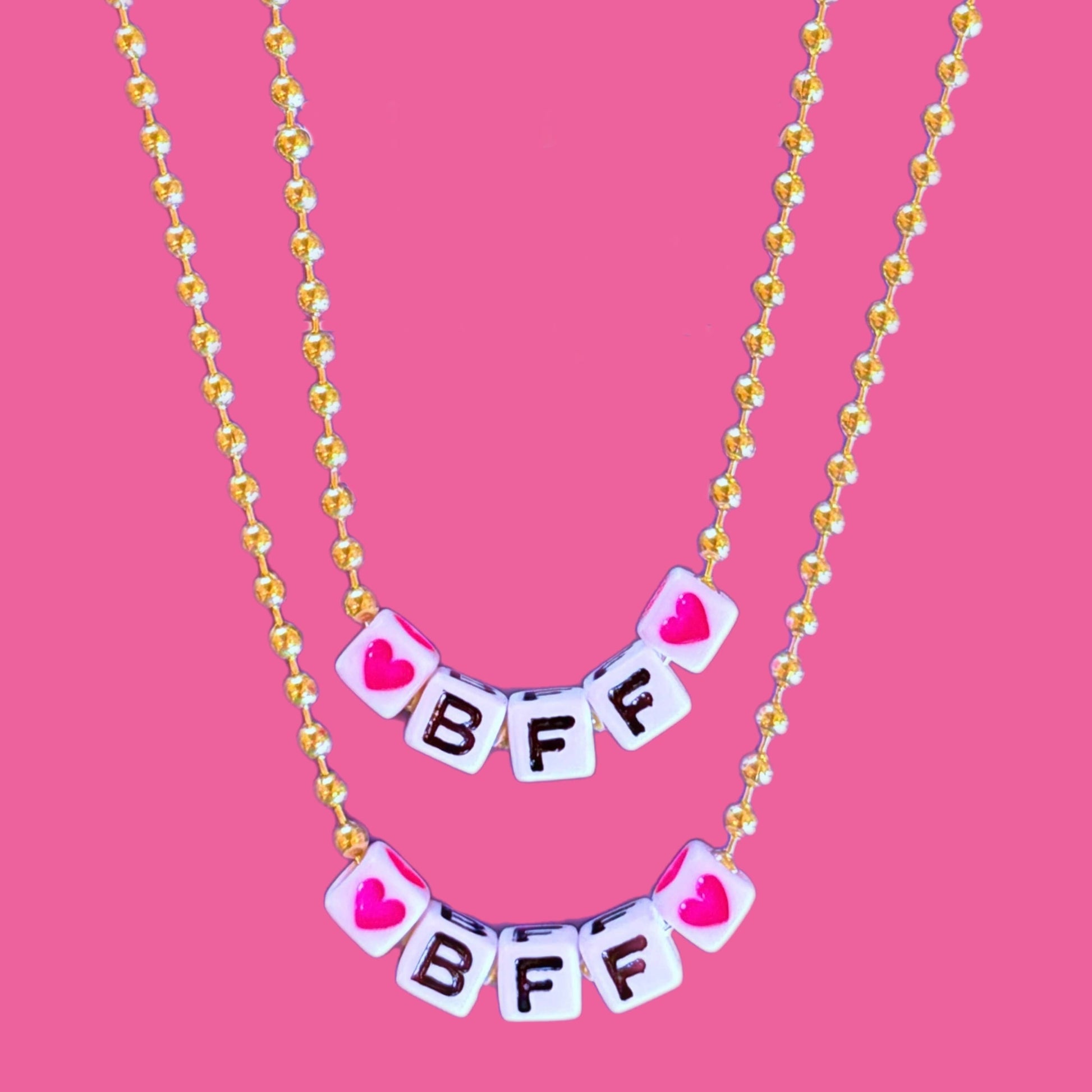Necklace with 'BFF' letters on a pink background