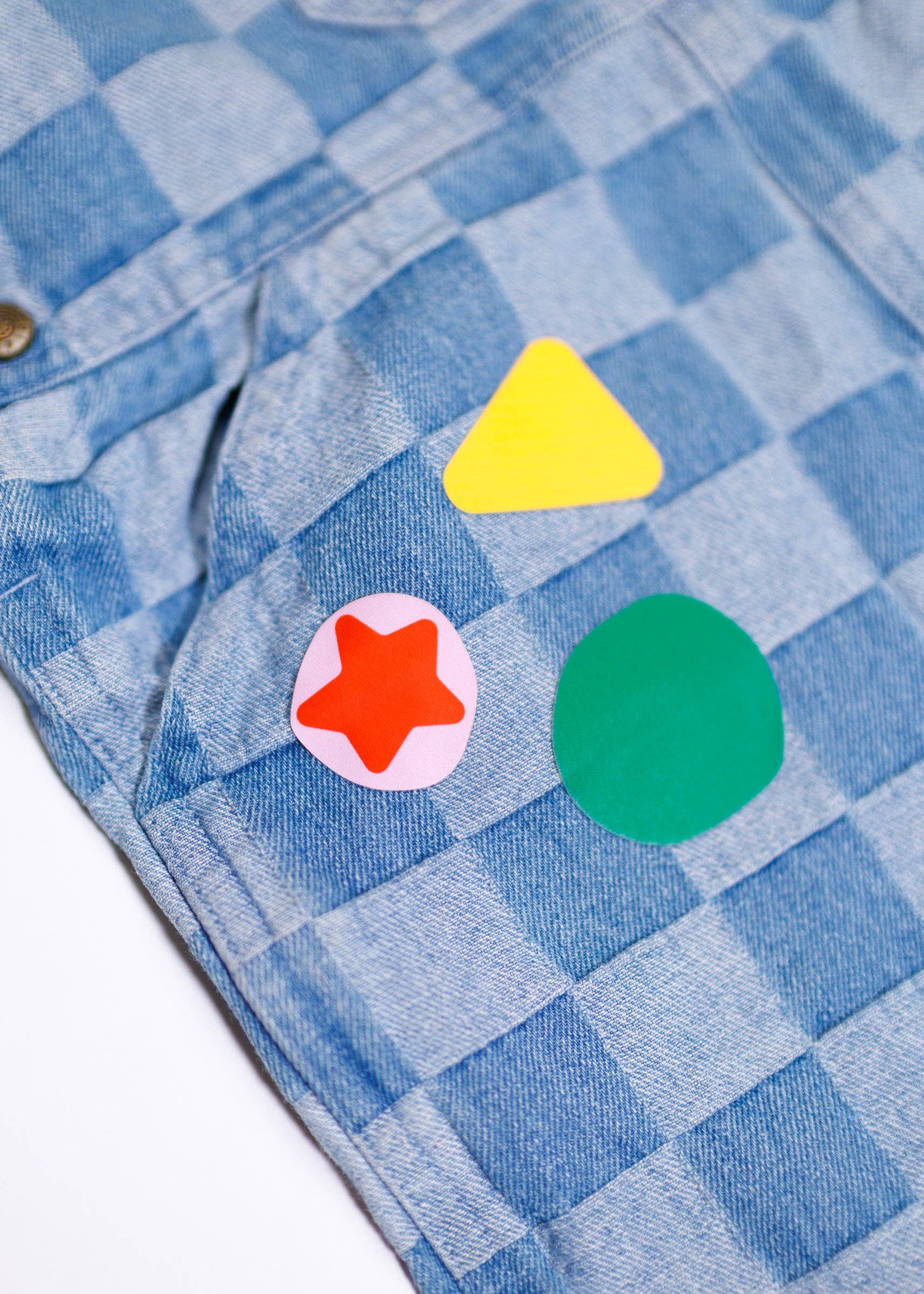 Colorful geometric shapes on a blue checkered fabric background