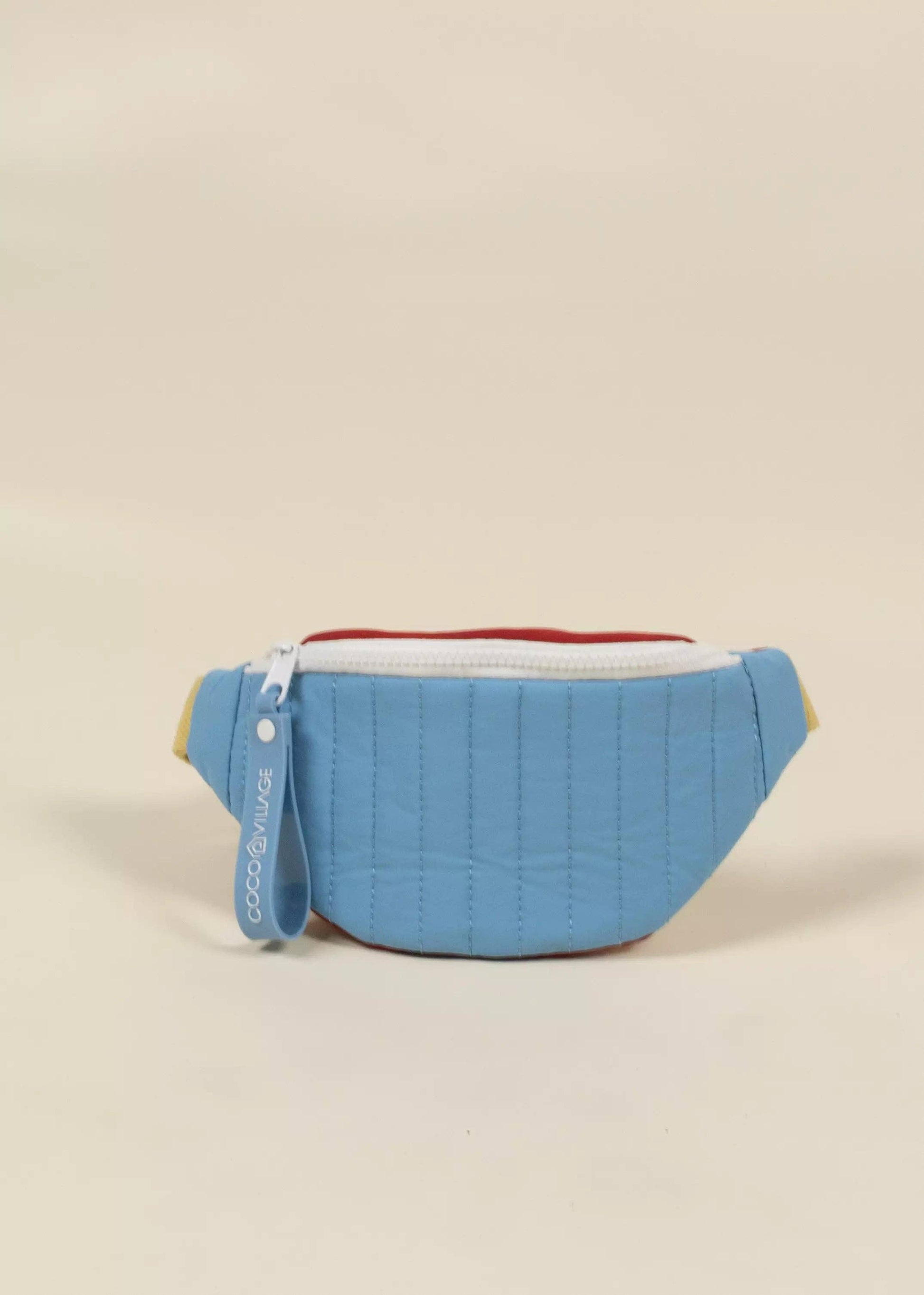 Blue quilted fanny pack on a beige background