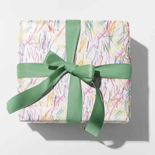 Gift box with colorful pattern and green ribbon on a white background