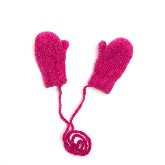 Pair of pink knitted mittens with a string on a white background